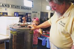 Steve lets Bailey extract honey from frames.